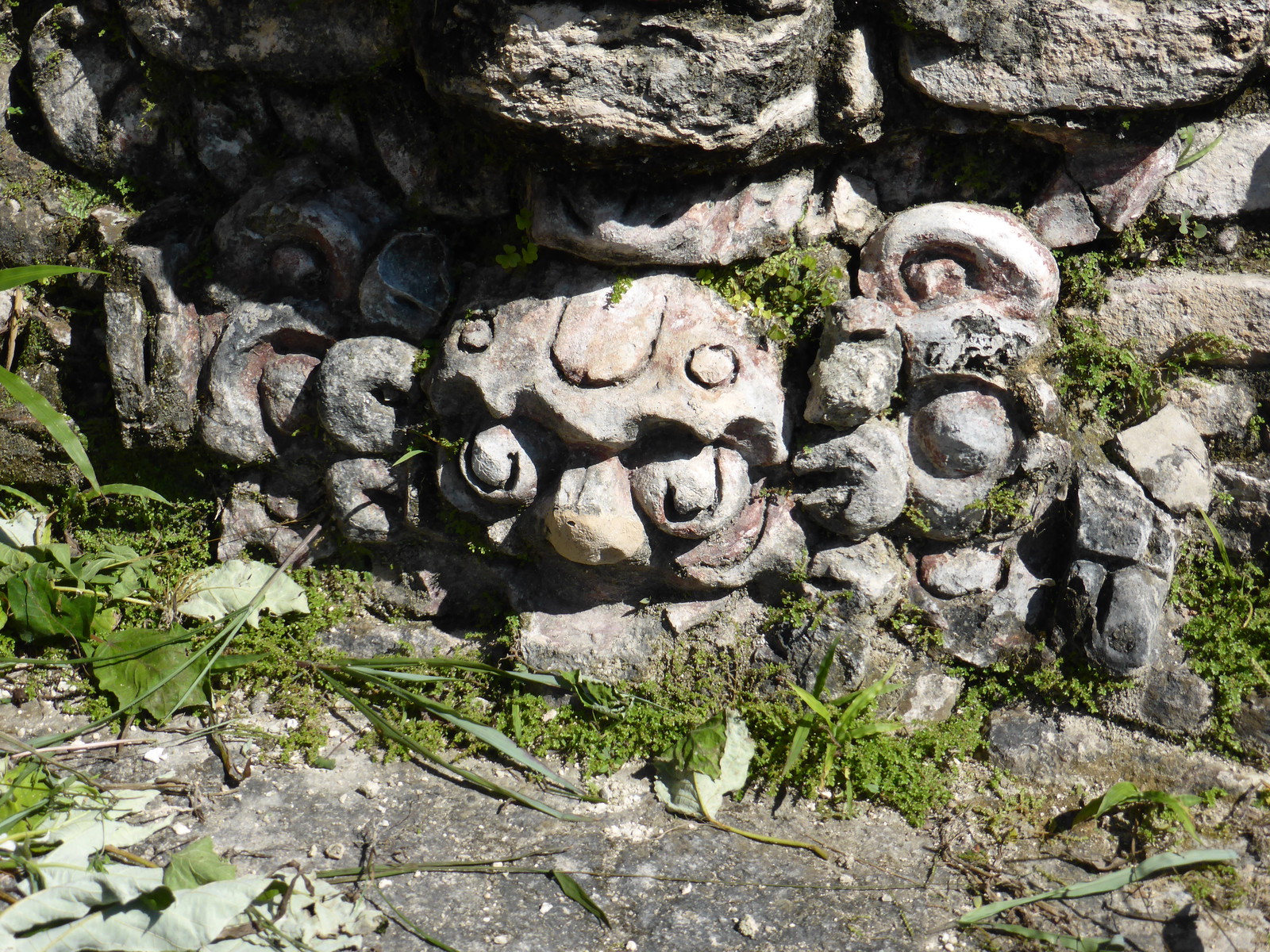 A carved mask on the top of the main pyramid