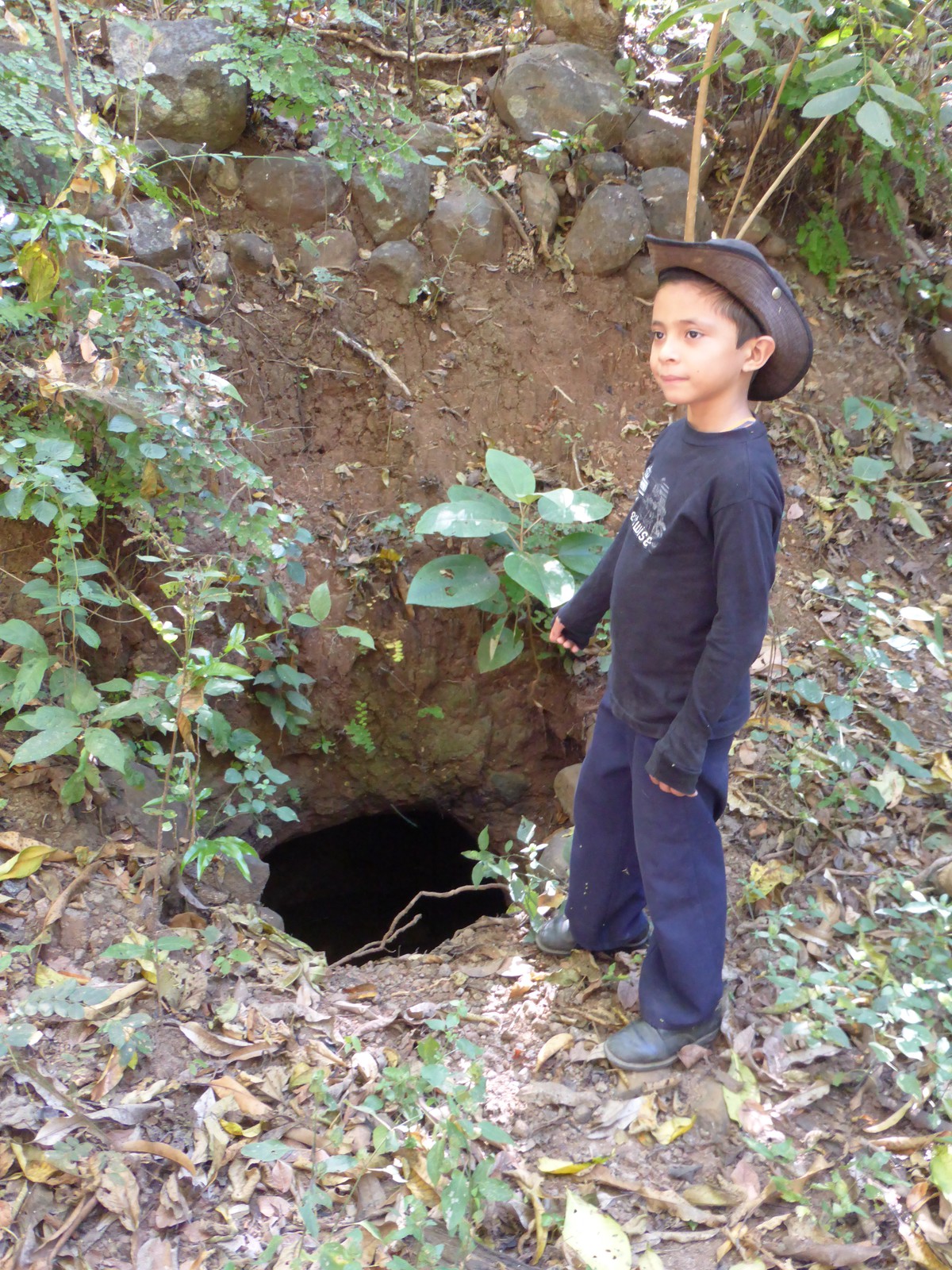 Nelsito pointing to a hole that locals used to shelter from the bombs