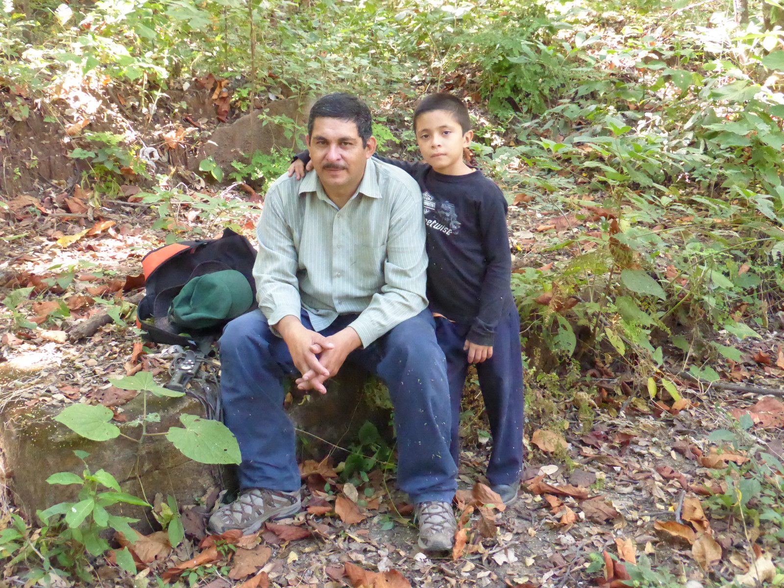 Nelson and son sitting in the remains of Nelson's family home