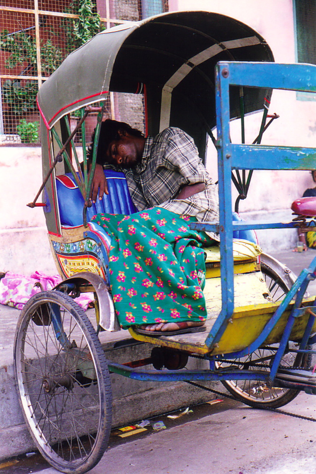 A rickshaw-wallah sleeping in his rickshaw