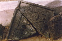 A carved stone slab with a skull and crossbones on it