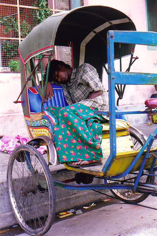 A rickshaw-wallah sleeping in his rickshaw