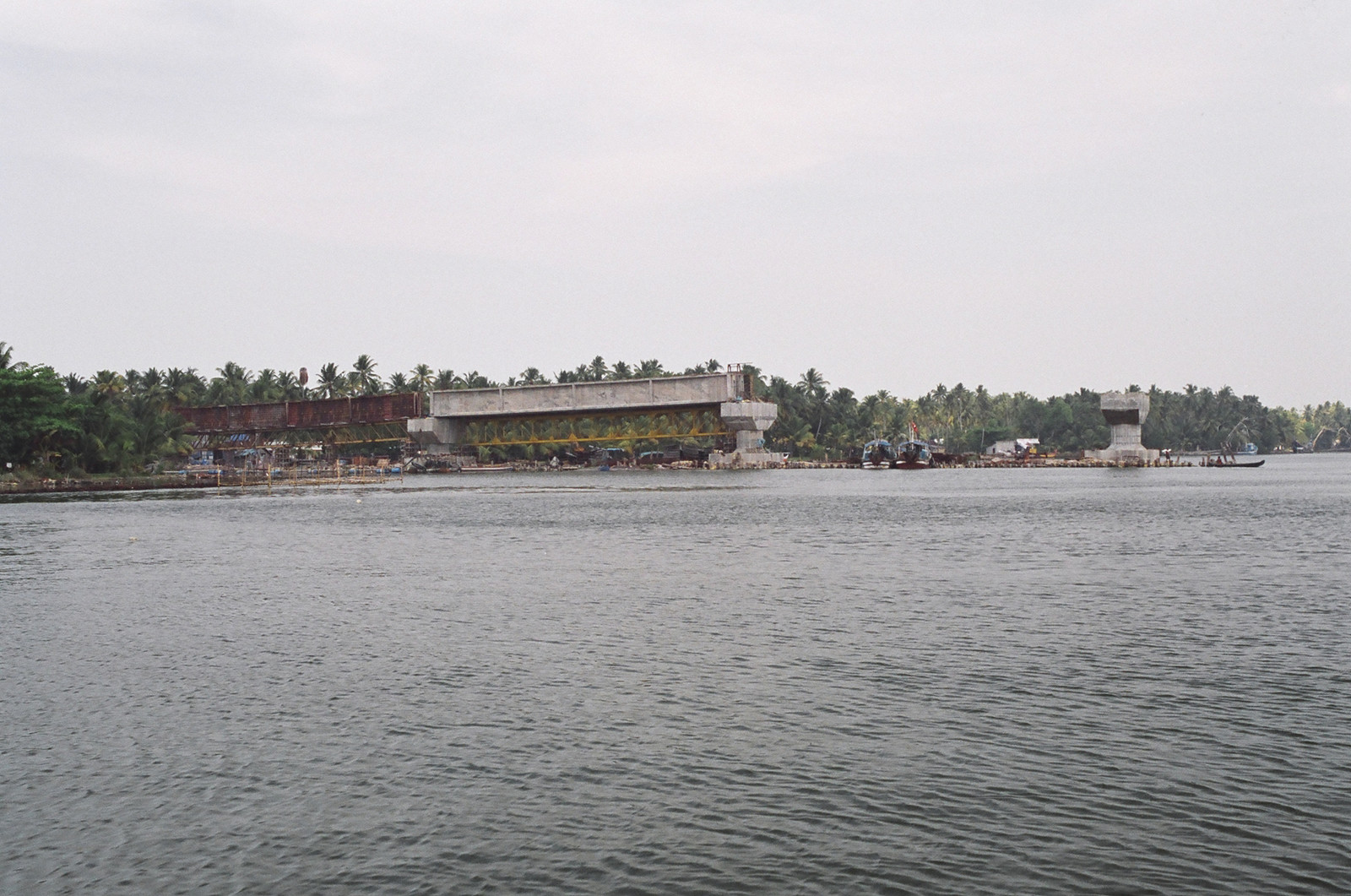 A large, half-built bridge spanning the backwaters
