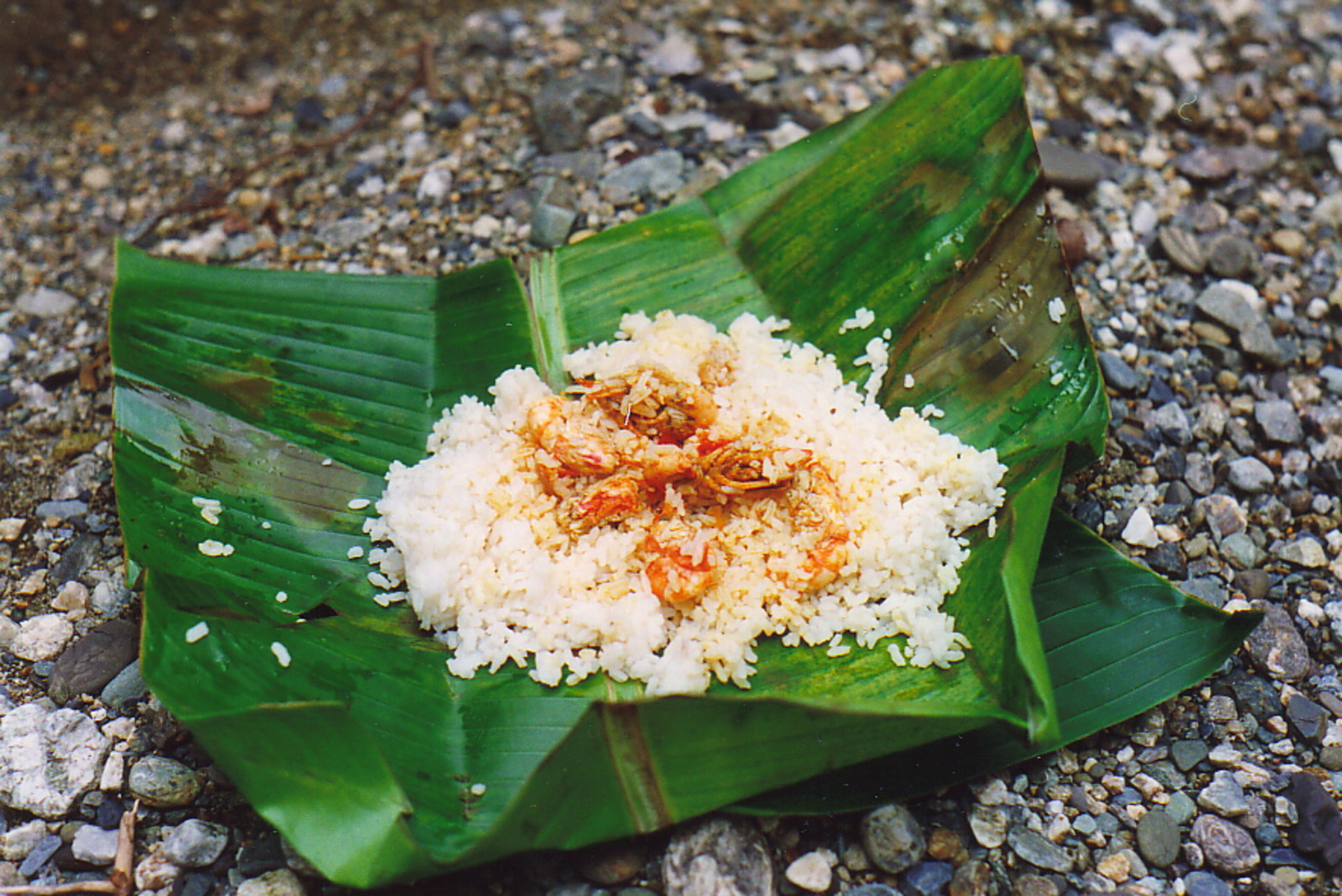A meal of prawns and rice in a banana leaf