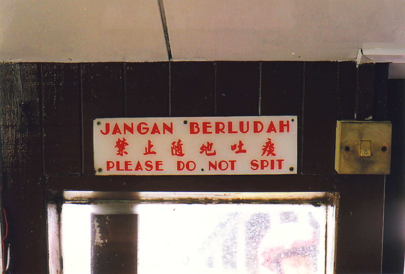 A sign saying 'No spitting' in three languages