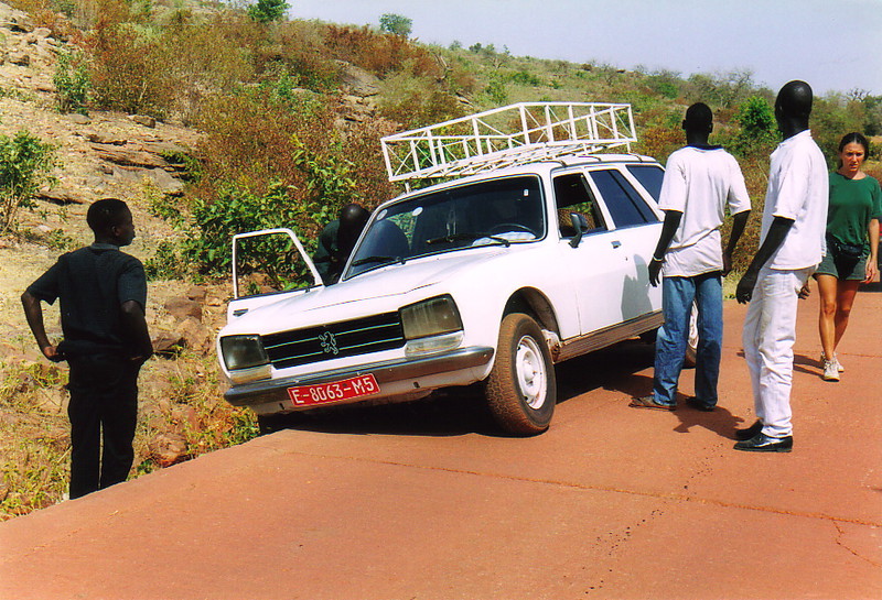 A taxi hanging off the side of the road