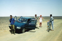 Mark and two hitchers talking to a man on a bicycle