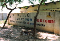 A Gambian toilet with a sign saying 'Customer Satisfaction is Our Concern'